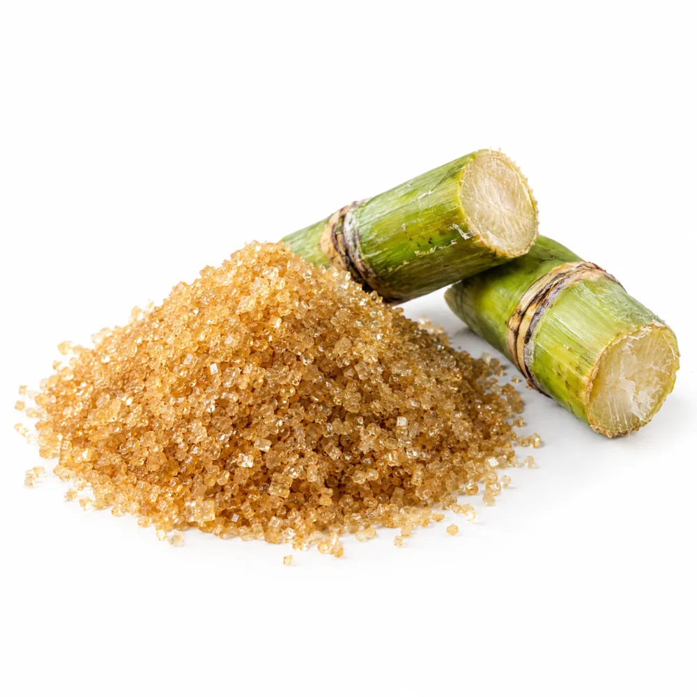 Raw cane sugar crystals beside cut sugar cane